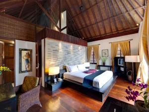 KetewelMajapahit Beach Villas by Nakula的一间卧室设有一张大床和砖墙