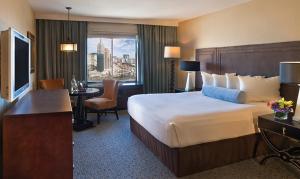 拉斯维加斯神剑大酒店的酒店客房配有一张床、一张书桌和一台电视。
