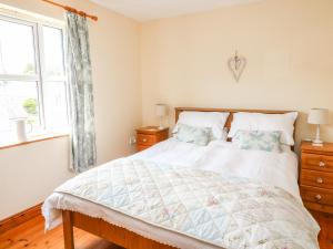 格伦加里夫18 Dalewood的一间卧室设有一张大床和一个窗户。