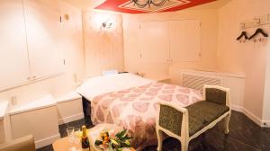 函馆樱花再住酒店（仅限成人）的卧室配有一张床和一张桌子及椅子