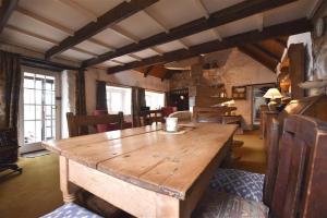 纽波特Ty-Newydd Cottage的配有椅子的房间里一张大木桌