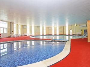卡林顿9 Manorcombe Bungalows的一座铺有红地毯的建筑里的大型游泳池