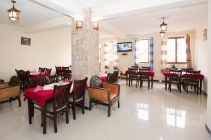 拉利贝拉Honey Land Hotel Lalibela的一间带桌椅和壁炉的用餐室