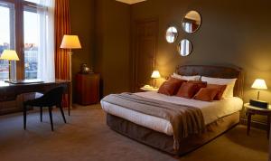 里尔加尔顿酒店的一间卧室配有一张床、一张书桌和一面镜子