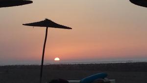 布兹尼盖Bahia Golf Beach的海滩上的日落和遮阳伞