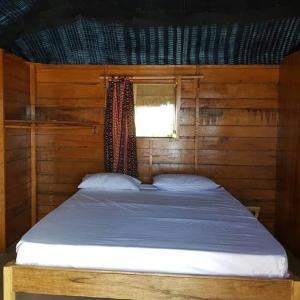 Mar LodjCap Marniane的木制客房的一张床位,设有窗户