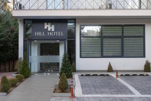 雅典HOTEL HILL的前面有一座建筑,上面有一座豪华的酒店标志