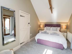 ThirskWoodside Barn的一间卧室设有一张大床和一个大镜子