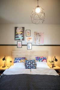PerroyCasa ViniToscani的一间卧室配有一张床和两盏灯,墙上挂着图片