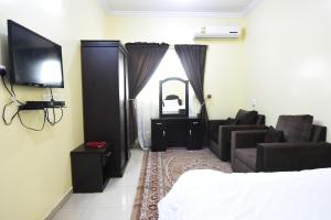 哈伊勒Al Eairy Apartments - Hail 3的一间卧室配有一张床、一台电视和一张沙发