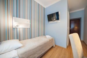 克拉科夫普瑞米安旅馆的卧室配有一张床,墙上配有电视。
