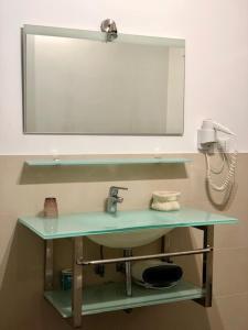 索里亚诺内尔奇米诺埃里莫冬宫酒店的浴室水槽、镜子和电话