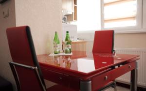 伊万诺-弗兰科夫斯克豪华公寓式酒店的上面有三瓶的红色桌子