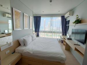 纳仲天Veranda Residence by VS的卧室设有白色的床和大窗户