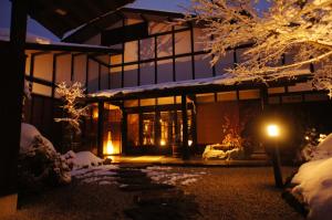 高山飞騨路传统日式旅馆（仅限成人入住）的地面上积雪的夜晚房屋