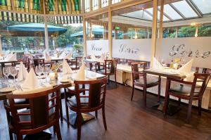 希佛萨姆兰佩夏克阿伦那帕阿姆拉酒店的餐厅设有木桌、椅子和窗户。