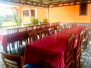 Tumpat马埃纳沃特乡村民宿的一张长桌子和椅子,配有红色的桌布