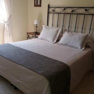 巴克罗斯Carmen的卧室配有带白色枕头的大床