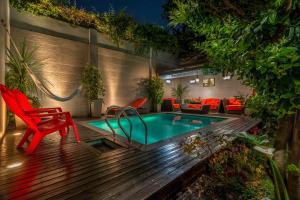 布宜诺斯艾利斯杜克Spa精品酒店的一个带小型游泳池和红色椅子的庭院