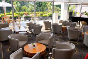 塔那那利佛马达加斯加卡尔顿酒店的一间带桌椅和钢琴的餐厅