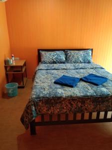 阁遥岛Baan Gebsup บ้านเก็บทรัพย์的一间卧室配有一张带蓝色枕头的床。