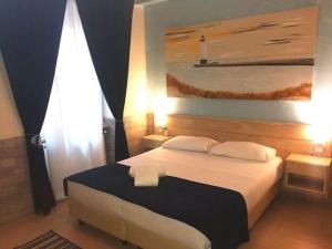 菲乌米奇诺夫米希诺机场豪华酒店 的卧室配有一张床,墙上挂有绘画作品