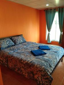 阁遥岛Baan Gebsup บ้านเก็บทรัพย์的一间卧室配有一张带蓝色毛巾的床