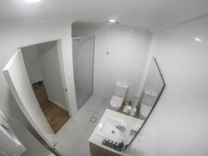 珀斯1 Bdrm Close Airport/Shops, WIFI, NETFLIX, PARKING的浴室设有镜子、盥洗盆和卫生间