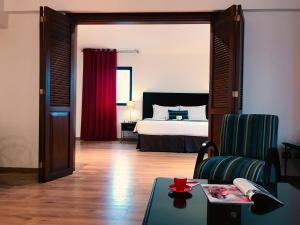 利马萨尔瓦多罗公寓酒店 的卧室配有1张床、1张桌子和1把椅子
