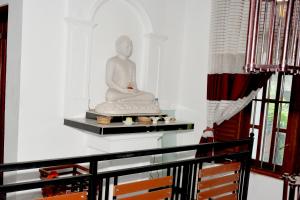 马特勒Sumimal Resort Polhena的坐在一个房间架子上的雕像
