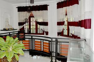 马特勒Sumimal Resort Polhena的一间设有红色和白色窗帘的房间和一座建筑