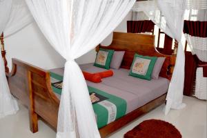 马特勒Sumimal Resort Polhena的卧室配有带白色窗帘的天蓬床