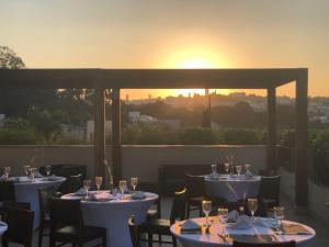 瓦利尼乌斯瓦林和斯蓝树酒店的餐厅设有桌子,享有日落美景