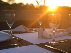 瓦利尼乌斯瓦林和斯蓝树酒店的餐桌上摆放着酒杯,享有日落美景