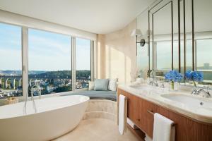 里斯本Corinthia Lisbon的带浴缸的浴室和大窗户