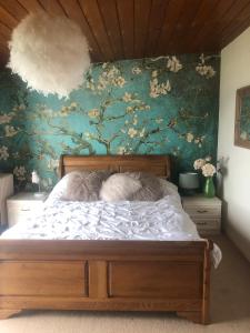 拉恩Ballygally Seaview Cottage的卧室内的一张床位,卧室内拥有花卉墙