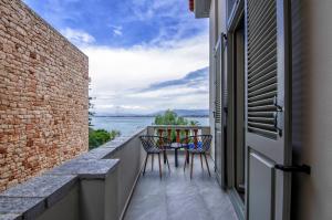 纳夫普利翁Impero Nafplio Hotel & Suites的阳台配有两把椅子,享有水景