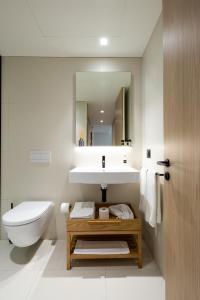 波尔图BessaApartments的一间带水槽、卫生间和镜子的浴室