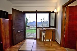 蒙达里斯Vinosobroso Casa Rural的一间设有桌子的房间和一扇带窗户的门