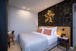 特拉维夫Artist Hotel - an Atlas Boutique Hotel的一间卧室配有一张床,墙上挂着绘画作品