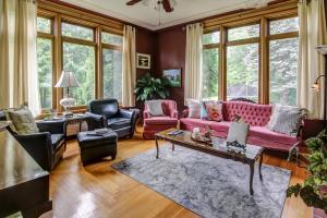 萨格奈Chateau Murdock Gite et Esthétique 1950的客厅配有粉红色的沙发和椅子