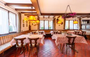 西蒙斯瓦尔德城堡山景观酒店的餐厅设有桌椅和窗户。