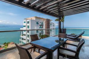 巴亚尔塔港Shangri La Luxury Penthouse Condominiums by Cheap Getaway的海景阳台上的桌椅