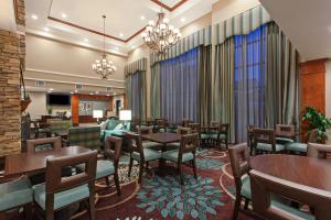 森林湖Staybridge Suites Irvine East/Lake Forest, an IHG Hotel的用餐室设有桌椅和窗户。