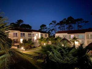 埃斯特角城埃斯特角城阿里纳斯酒店的棕榈树和建筑的夜间酒店