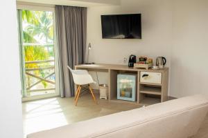 卡塔赫纳Melia Cartagena Karmairi的客厅配有书桌、电视和椅子