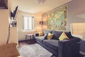 普瓦捷La Maison de la Liberté Studio Jules Verne的客厅配有沙发和墙上的绘画
