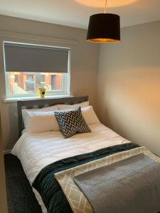 贝尔法斯特Weekend City Break Plush Pad的一间卧室配有一张带窗户和灯的床