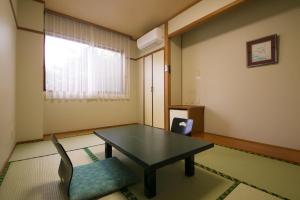 屋久岛田代复式酒店的客房设有桌子、椅子和窗户。