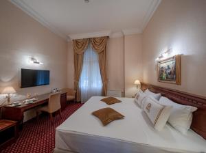 奥西耶克瓦尔丁格酒店的酒店客房设有一张大床和一张书桌。